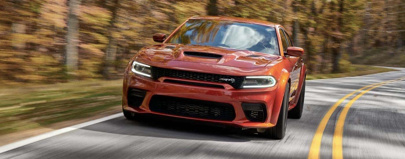 Orange 2022 Dodge Challenger Hellcat shown from the front driving on a road