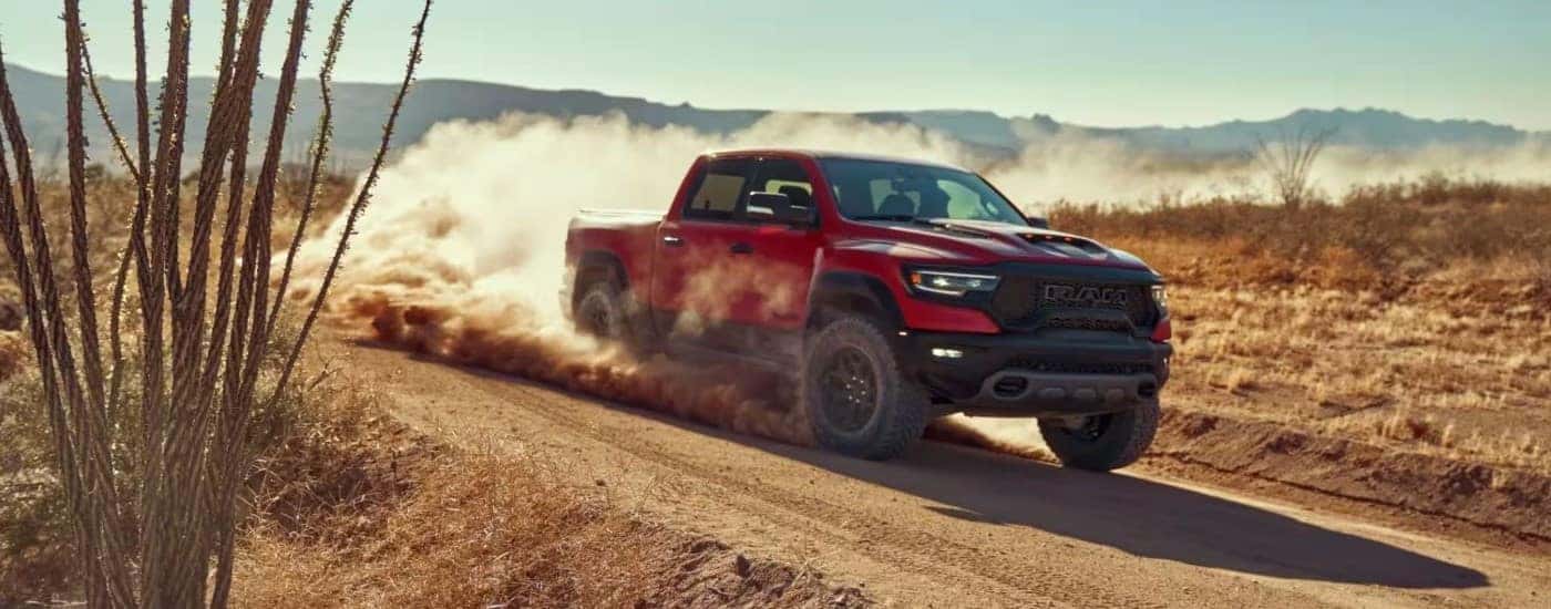 Red 2022 Ram 1500 TRX driving through the desert and sending up dust