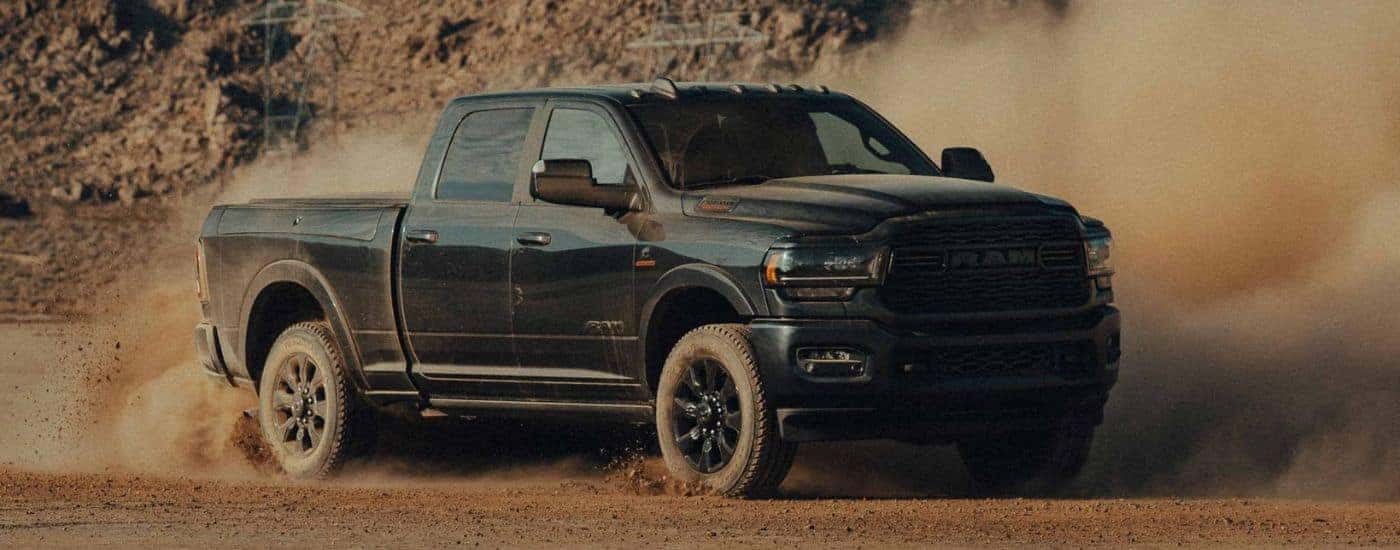 Black 2022 Ram 2500 driving through the dust filled desert