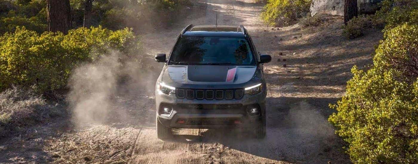 Grey 2023 Jeep Compass Trailhawk driving on a dusty road