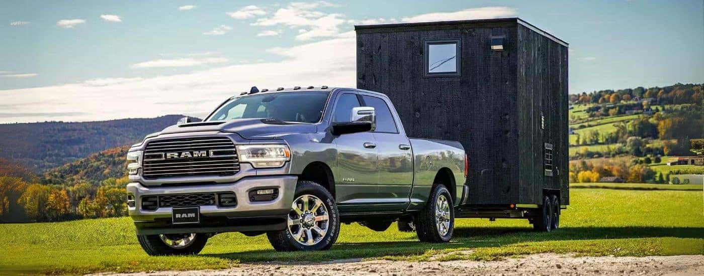 A silver 2024 Ram 2500 is shown towing a shed.