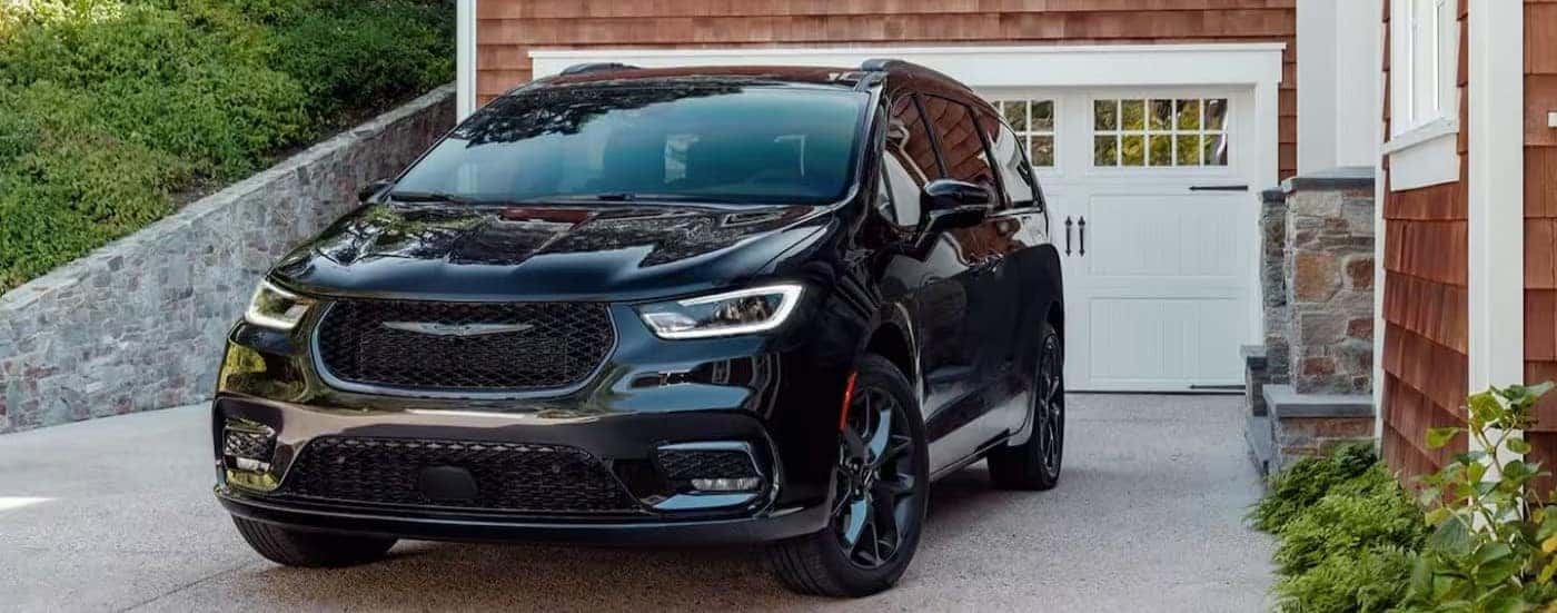 A black 2024 Chrysler Pacifica is shown parked in a driveway.
