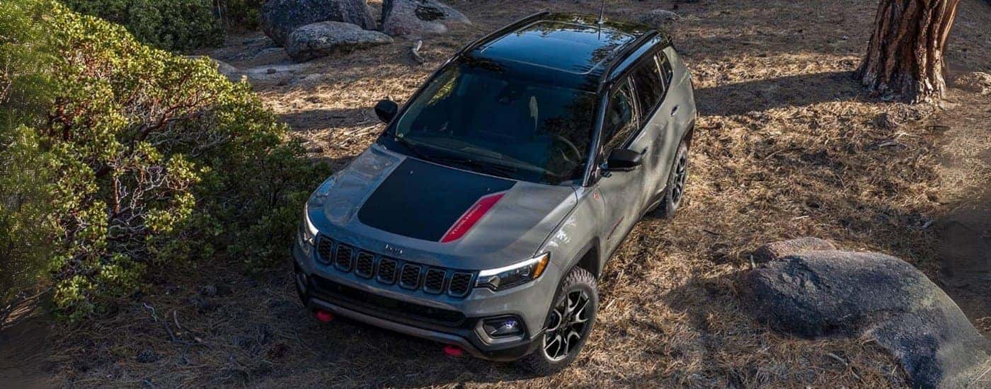Overhead view of a grey 2024 Jeep Compass Trailhawk driving in the woods.