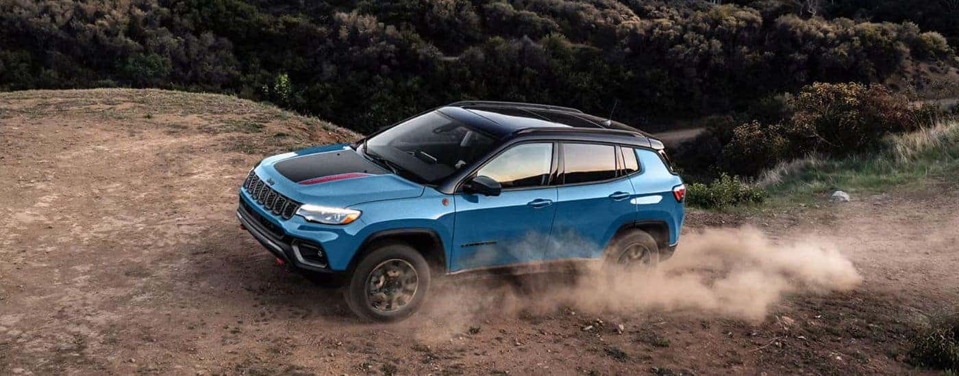 Blue 2026 Jeep Compass Trailhawk on a trail.
