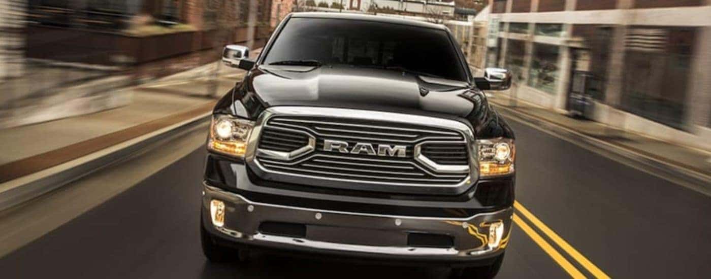 A black 2018 Ram 1500 is shown from the front driving.