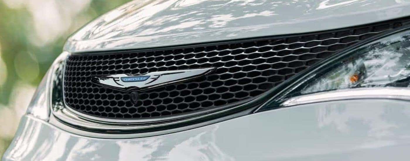 A close up shows the grille of a white 2020 used Chrysler Pacifica.