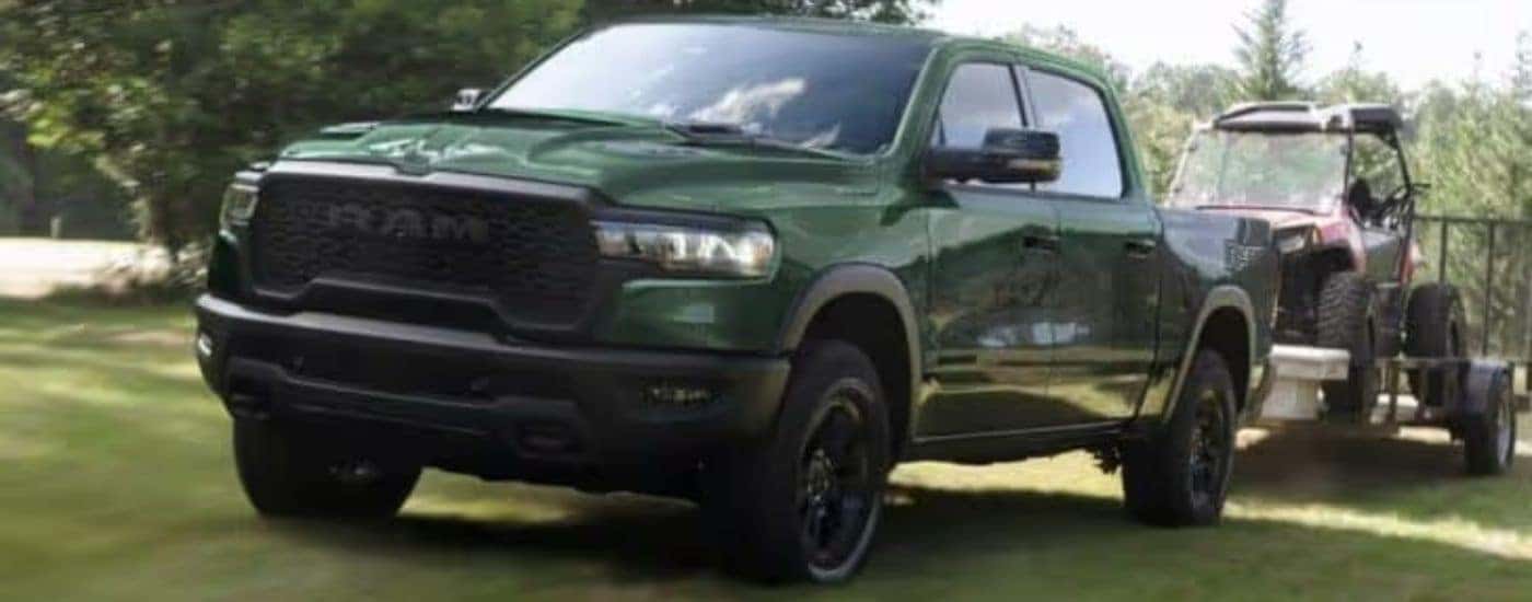 A green 2024 Ram 1500 is shown towing a side by side.