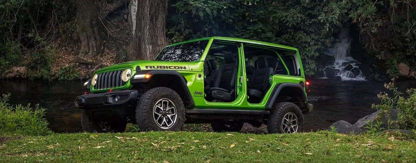 A lime green 2026 Wrangler Rubicon 4-door shown parked in the woods.