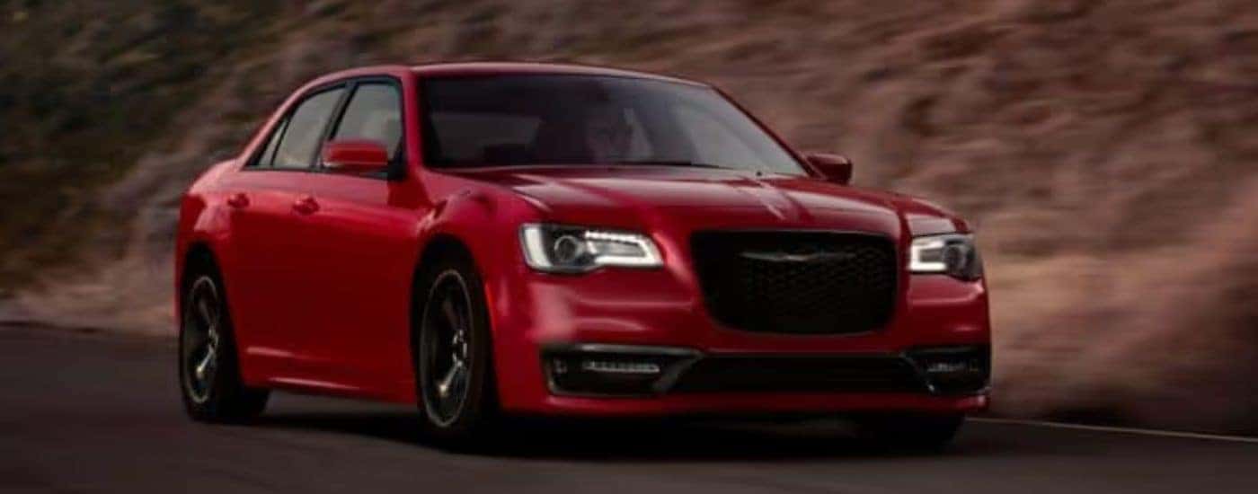 A red 2020 Chrysler 300 is shown driving on a road.