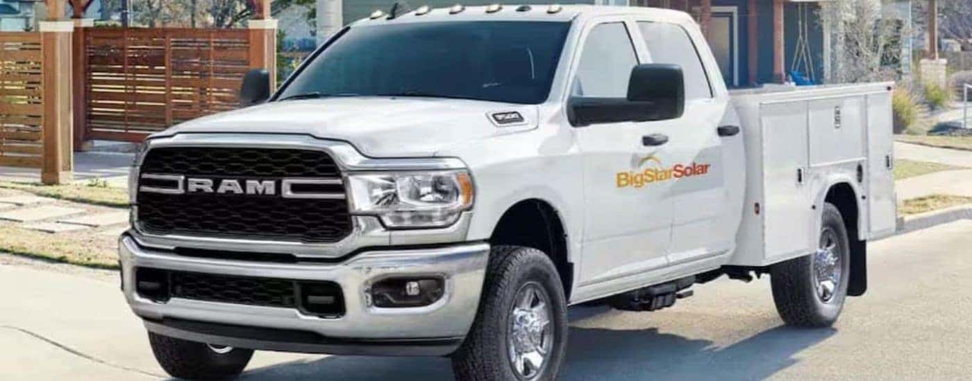 A white 2025 Ram 2500 Chassis Cab is shown parked near a house.
