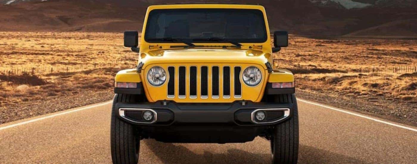 Head-on view of a yellow 2021 Jeep Wrangler in the desert.