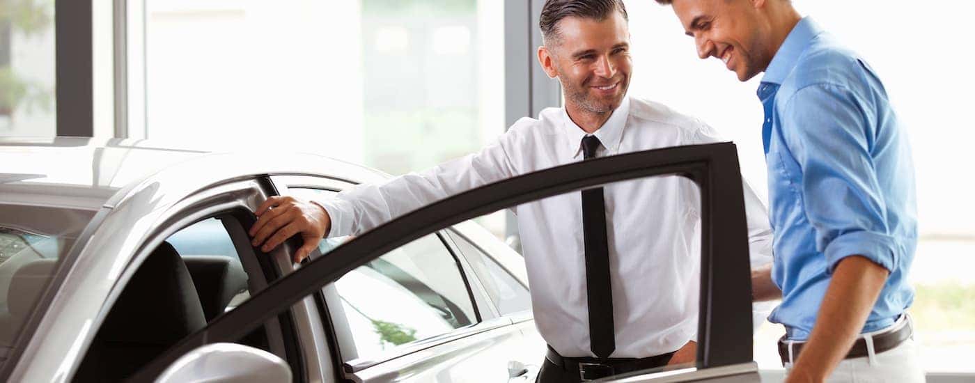 Salesman and customer talking about a used car