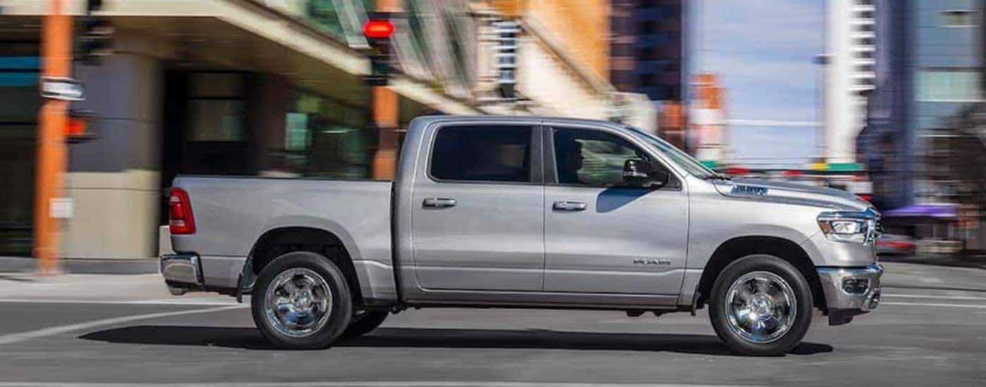 Side angle view of a white 2019 Ram 1500 stopped at an intersection.