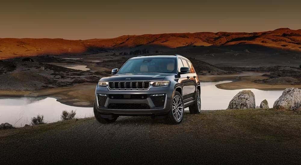 A gray 2026 Jeep Grand Cherokee parked near a pond.