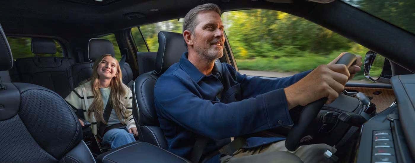 People driving in the black interior in a 2026 Jeep Grand Cherokee.