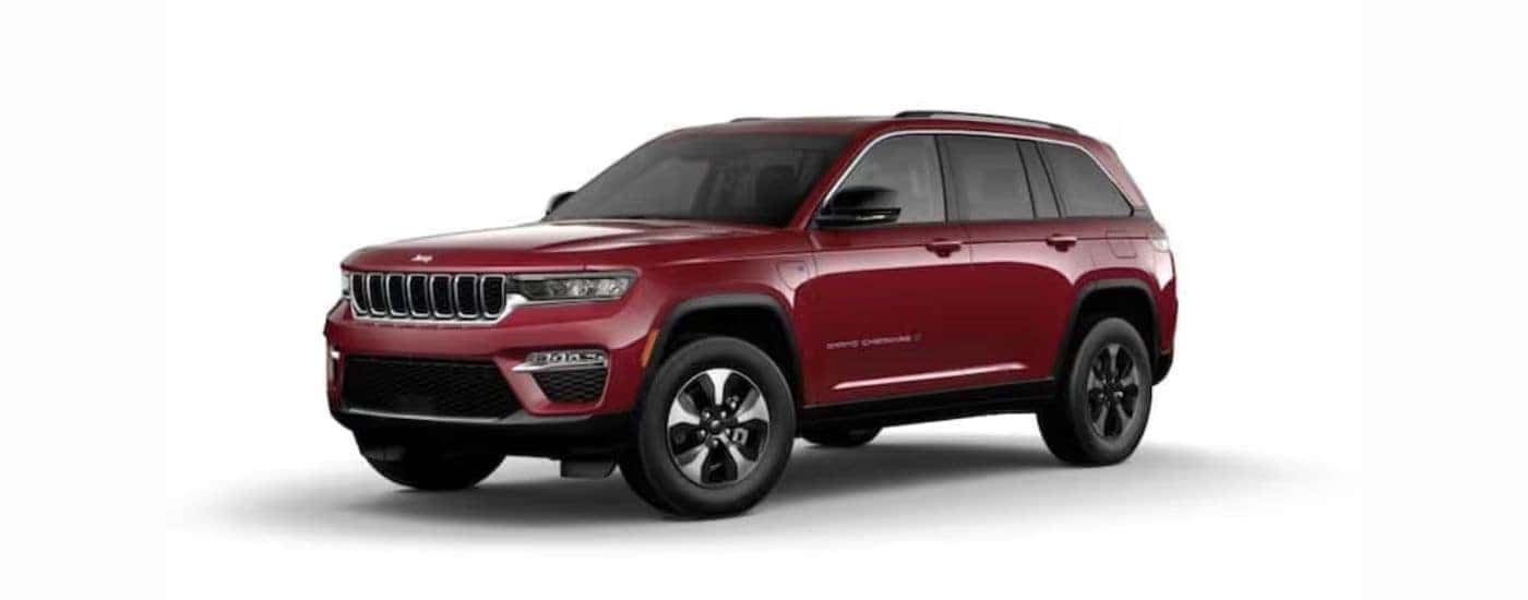 A red 2022 Jeep Grand Cherokee 4xe with a white background angled left.