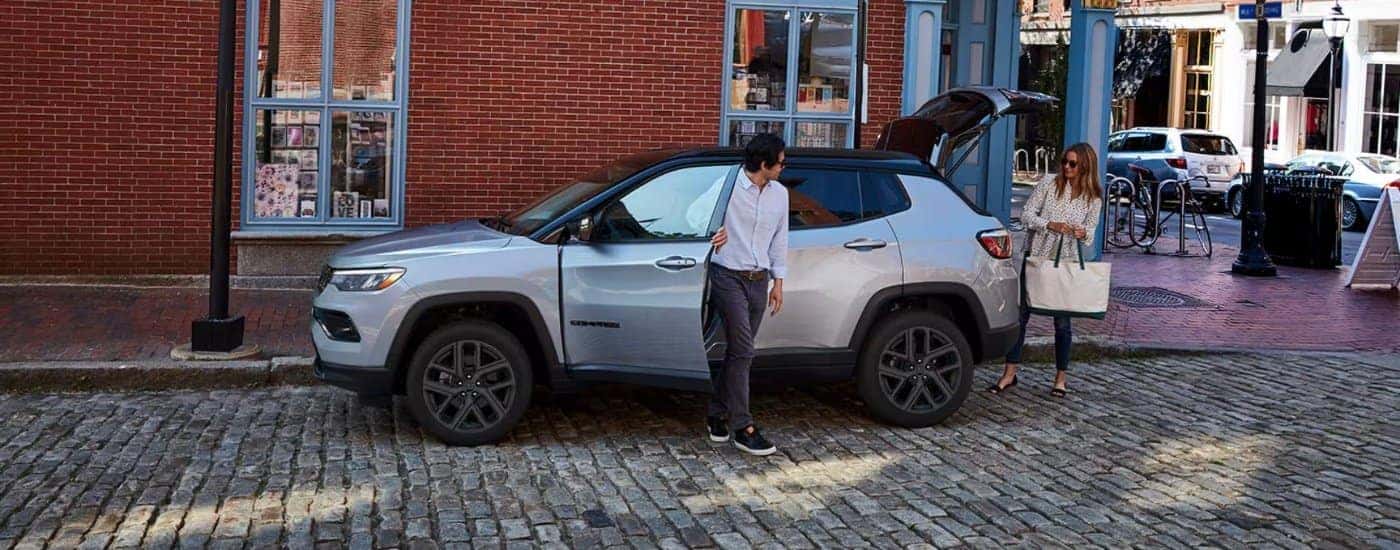 Silver 2026 Jeep Compass parked on front of a shop