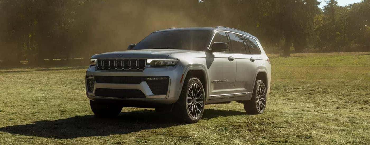 Silver 2026 Jeep Grand Cherokee parked on a field