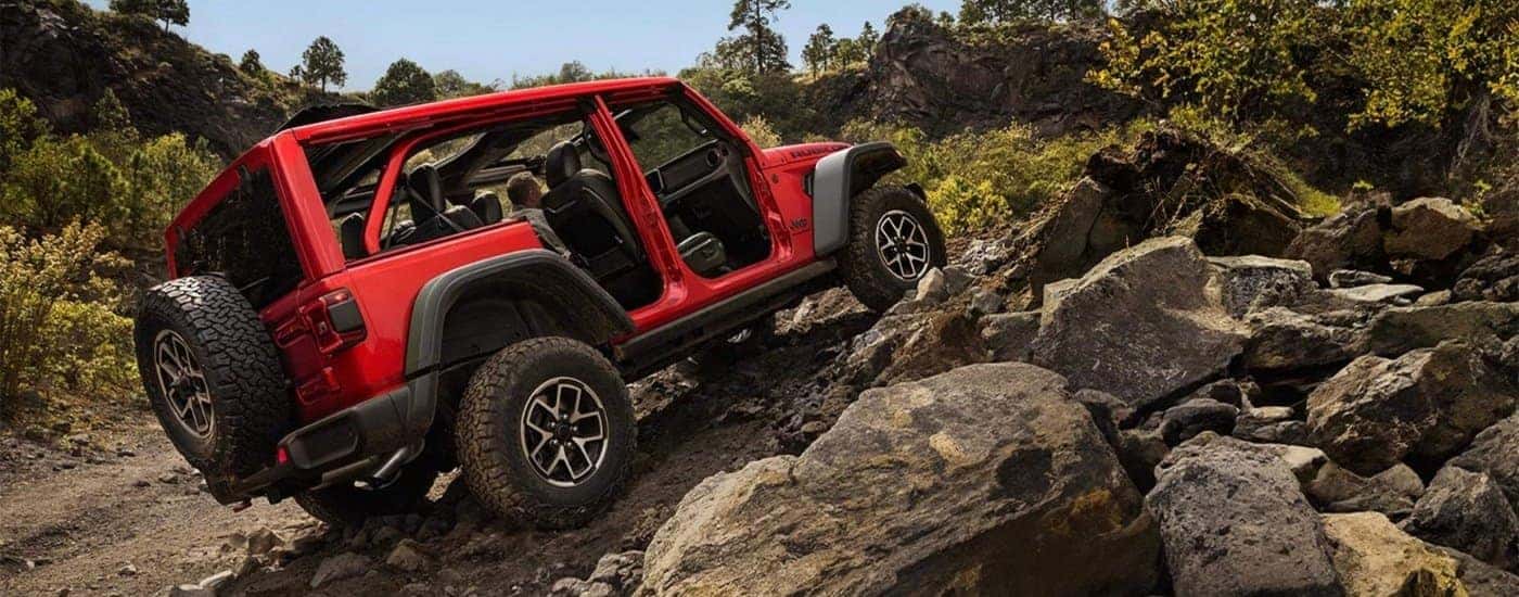 Red 2026 Jeep Wrangler Rubicon driving off-road