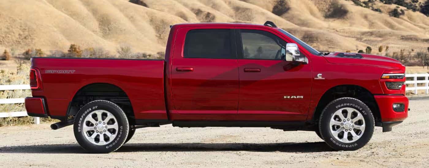 A side view of a red 2026 Ram 2500 Laramie parked at a ranch.