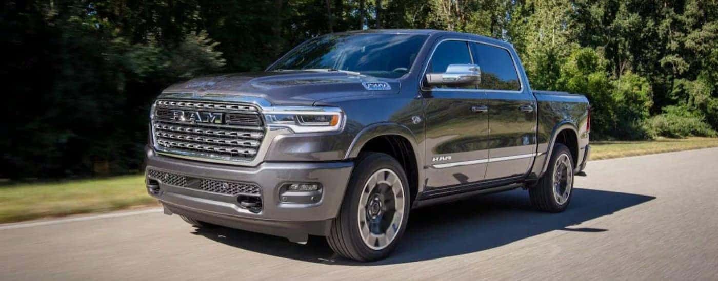 A gray 2027 Ram 1500 driving on a paved road.