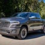 A silver 2027 Ram 1500 driving on a paved road.