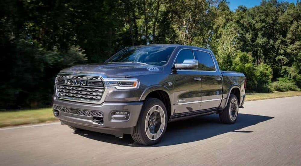 A silver 2027 Ram 1500 driving on a paved road.