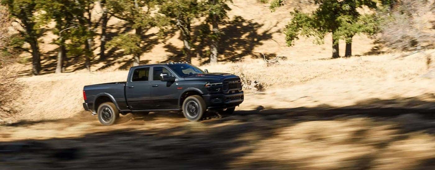 A dark gray 2026 Ram 2500 driving uphill.