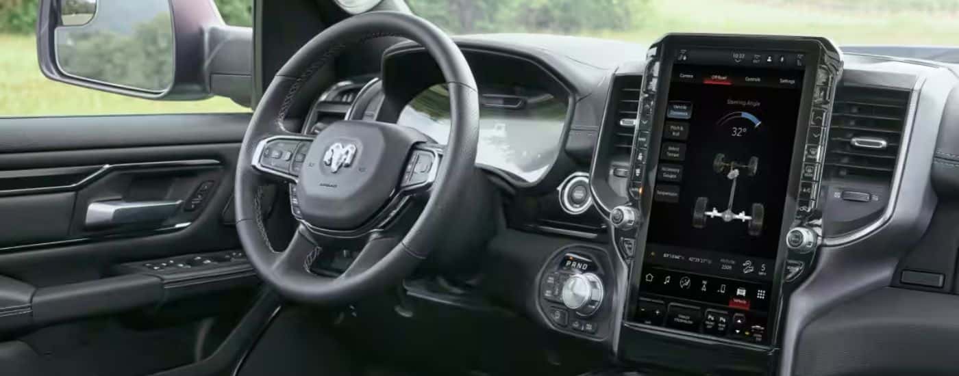 Interior view of a 2026 Ram 1500 steering wheel and touchscreen display.