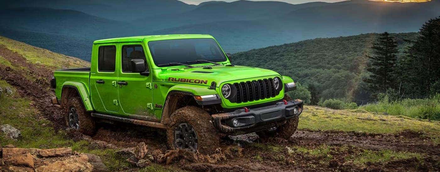 A green 2026 Jeep Gladiator Rubicon off-roading in mud