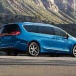 A blue 2027 Chrysler Pacifica parked near a mountain.