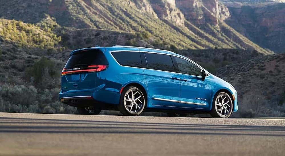A blue 2027 Chrysler Pacifica parked near a mountain.