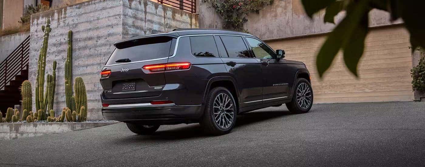 A rear-facing dark gray 2026 Jeep Grand Cherokee L parked in a driveway.