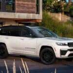 A white 2027 Jeep Grand Cherokee L parked in a driveway.