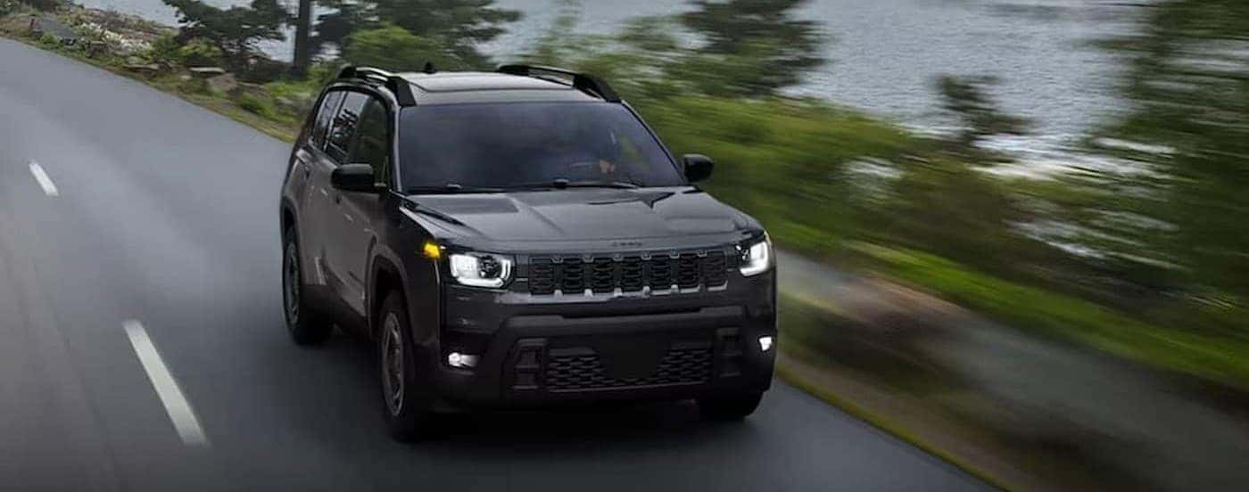 A gray 2026 Jeep Cherokee driving on a highway.