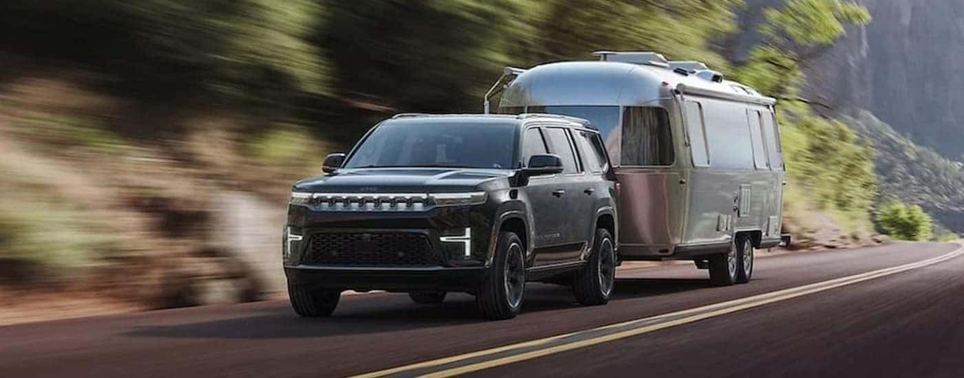 A gray 2027 Jeep Grand Wagoneer towing a trailer.