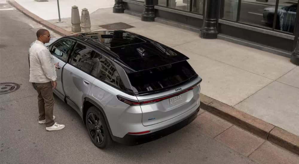 Rear view of a person entering their silver and black 2026 Jeep Wagoneer S.